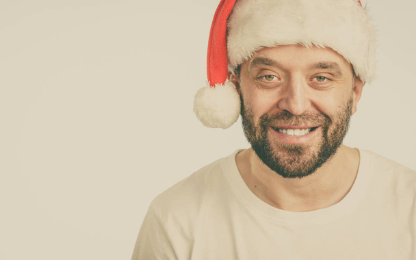 Bearded man wearing santa claus hat portrait, on blue with copy space. Christmas time. - Valokuva, kuva
