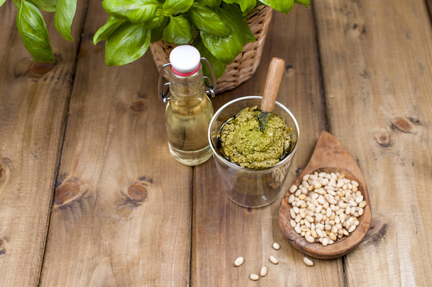 Fresh green sweet basil in a pot and pesto sauce with nuts and cheese. ITALIAN HERBS FOR COOKING. Copy space - Zdjęcie, obraz