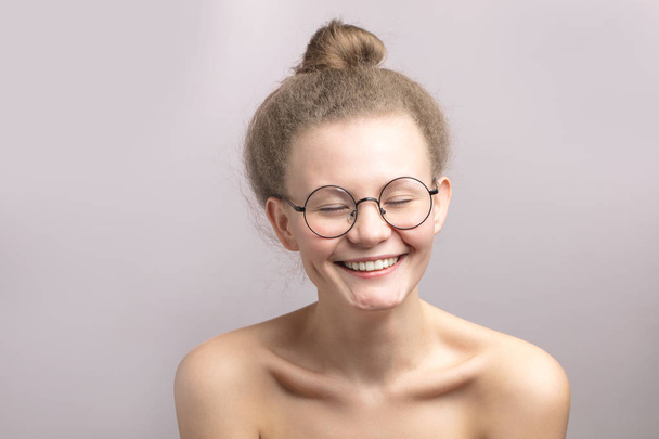 cheerful pleasant girl with closed eyes in glasses - Valokuva, kuva