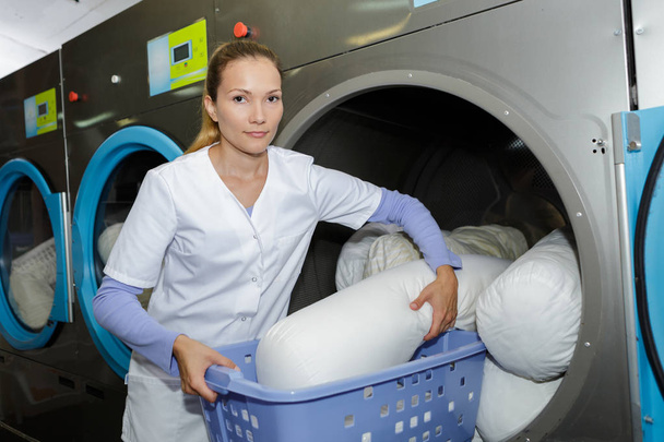 happy female employee with laundry basket - Foto, immagini