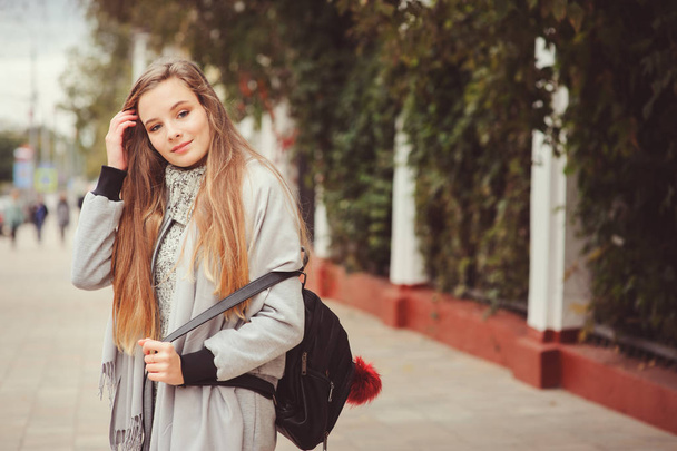 street style portrait of young beautiful happy girl walking in autumn city with trendy leather backpack - Foto, imagen