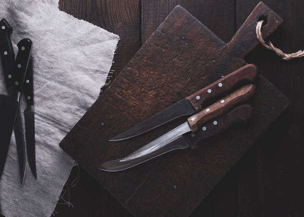 molto vecchio tagliere marrone legno e coltelli da cucina, vista dall'alto
 - Foto, immagini