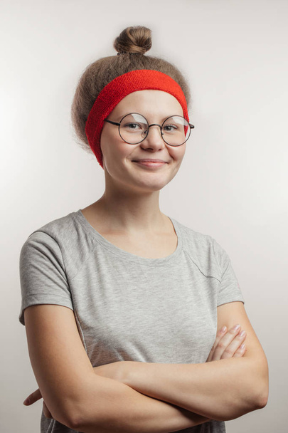positive girl with hairbun keeping arms crossed - Fotografie, Obrázek
