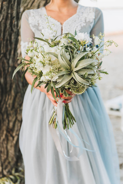 Bride wearing light blue wedding dress holding bouquet - Fotoğraf, Görsel