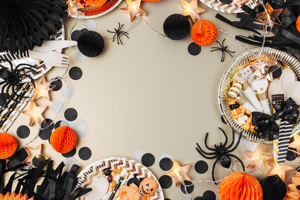 Halloween Table setting. Frame made of black and orange party decoration stuff. Flat lay, top view - Zdjęcie, obraz