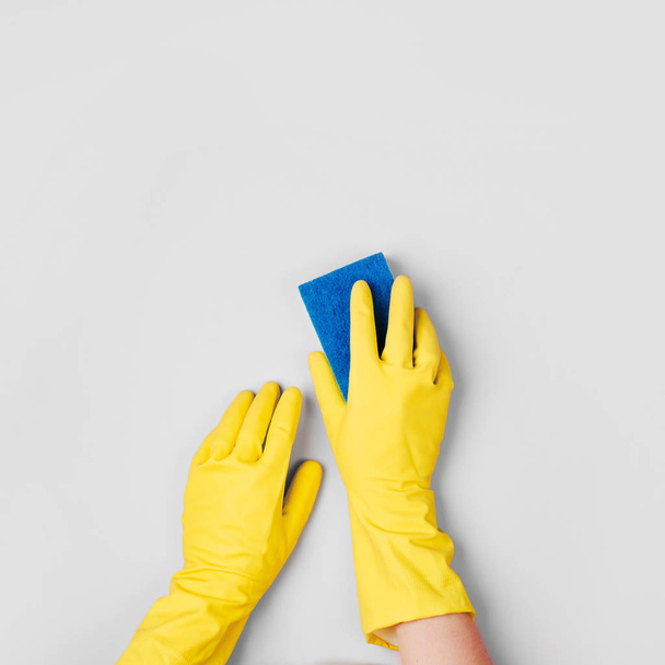 Female hands cleaning on pale pink  background. Cleaning or housekeeping concept background. Copy space.  Flat lay, Top view. - Photo, Image