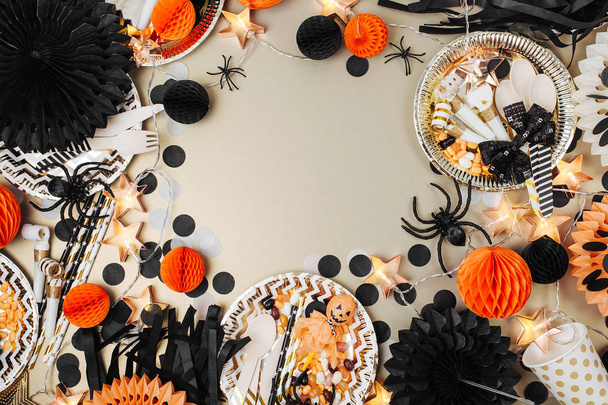 Halloween Table setting. Frame made of black and orange party decoration stuff. Flat lay, top view - 写真・画像