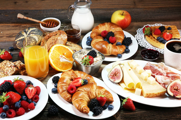 petit déjeuner sur table avec gaufres, croissants, café et jus de fruits
 - Photo, image