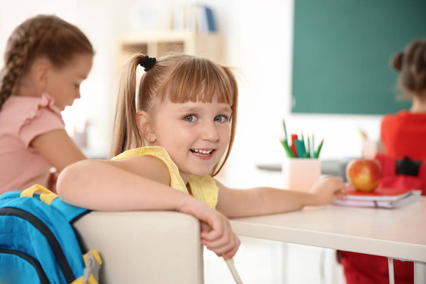 Cute little child sitting at desk in classroom. Elementary school - Foto, Imagem