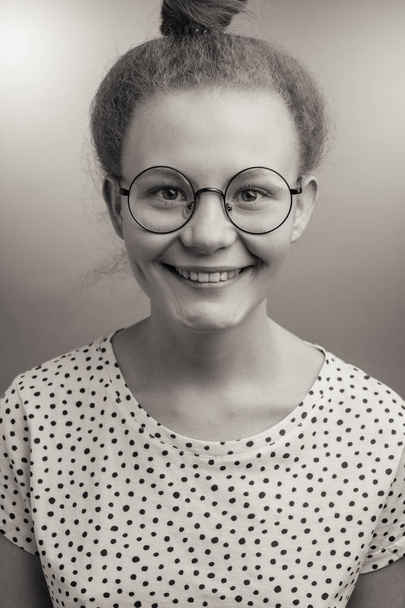 黒と白の写真。カメラを見て丸いメガネの若い女性 - 写真・画像