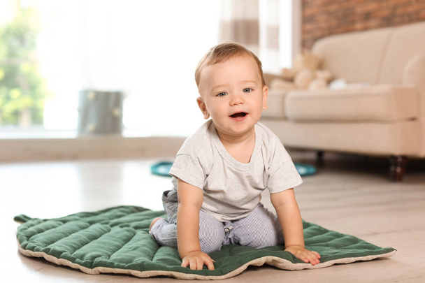 Adorable little baby sitting on floor at home - Foto, imagen