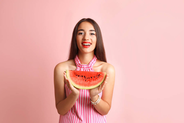 Beautiful young woman posing with watermelon on color background - Photo, Image