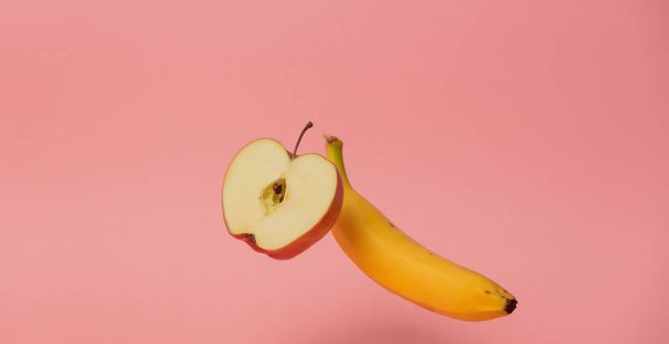 желтый банан и яблоко левитируют в воздухе
 - Фото, изображение