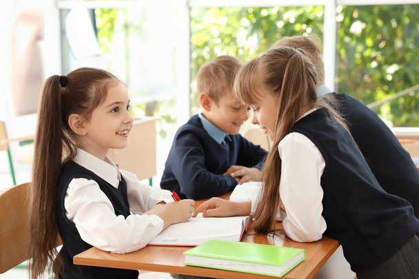 Little children in classroom. Stylish school uniform - 写真・画像