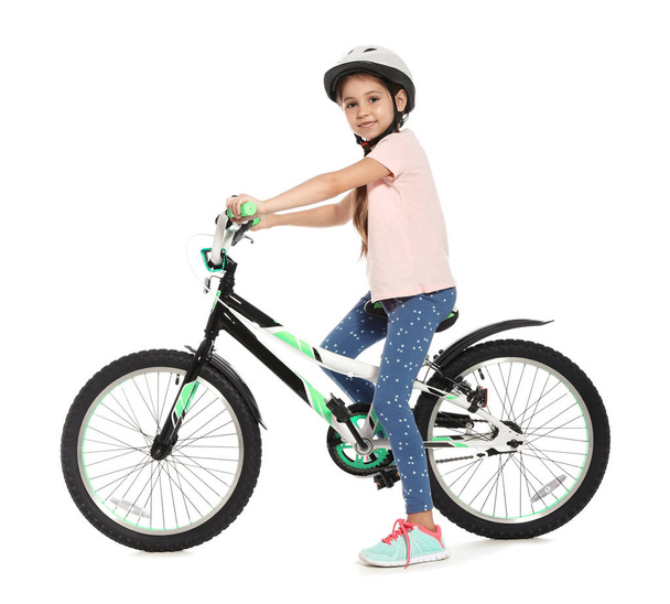 Portrait of cute little girl with bicycle on white background - Fotó, kép