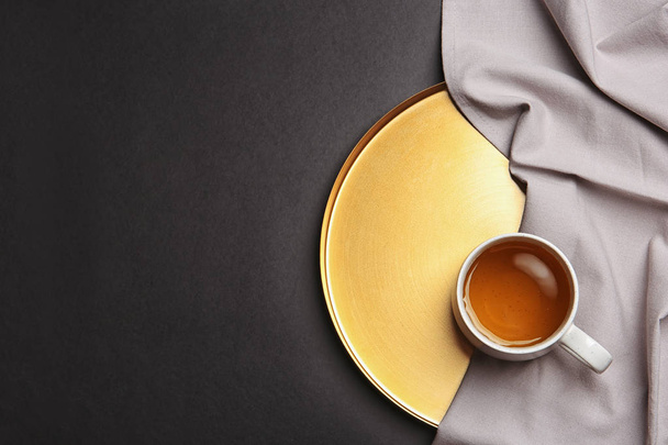 Tray with cup of tea on black background, top view - 写真・画像