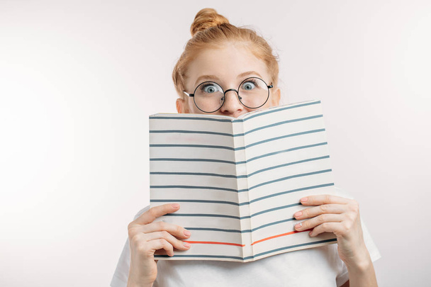 surprised girl holding a book. - Foto, afbeelding