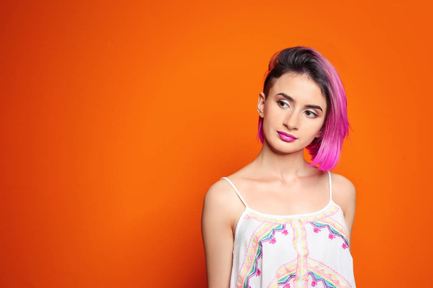 Young woman with trendy hairstyle against color background - Foto, Imagem