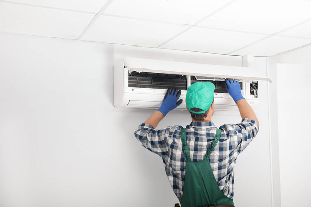 Mies teknikko puhdistus ilmastointi sisätiloissa - Valokuva, kuva