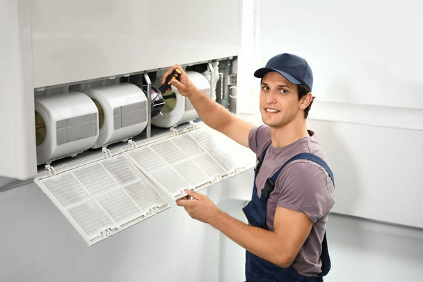 Male technician repairing air conditioner indoors - Foto, Imagem
