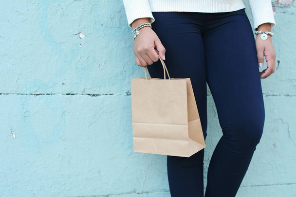 Mãos femininas segurando saco de compras ao ar livre. Uma mulher nas compras. Consumismo e conceito de estilo de vida
. - Foto, Imagem