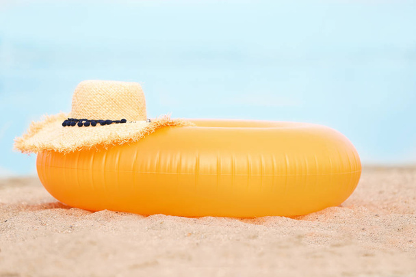 Colorful inflatable ring and hat on sand. Beach object - 写真・画像