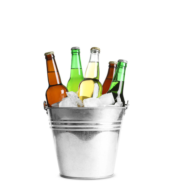 Garrafas com diferentes tipos de cerveja e gelo em balde de metal sobre fundo branco
 - Foto, Imagem