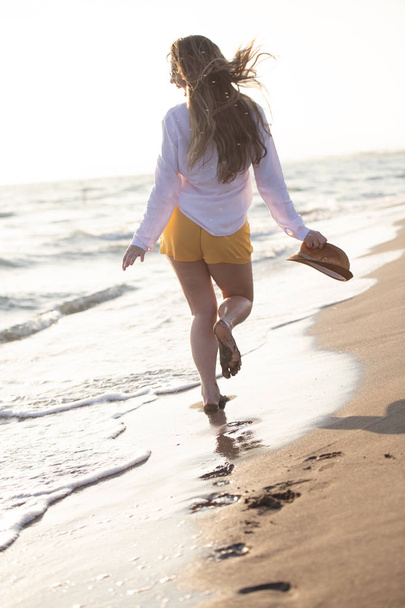 jeune femme heureuse marchant le long de la côte océanique
  - Photo, image