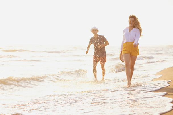 feliz pareja de amor caminando a lo largo de la costa océano
  - Foto, imagen