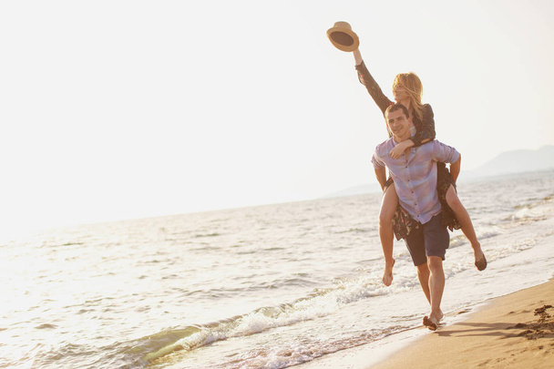  парень с женщиной на спине на пляже
 - Фото, изображение