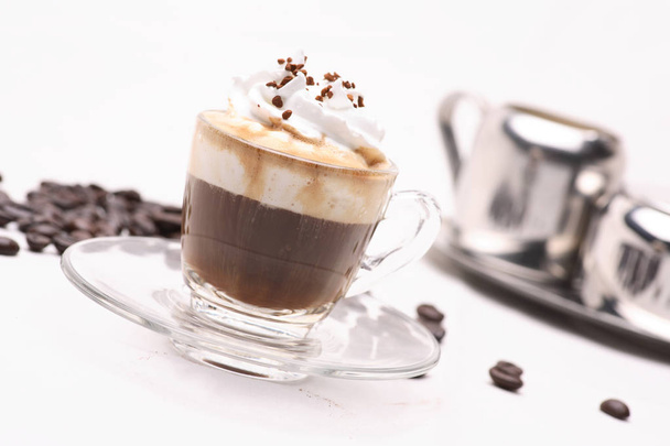 Café Espresso Con Panna chaud dans un verre clair sur un fond blanc avec des grains de café.in studio
. - Photo, image