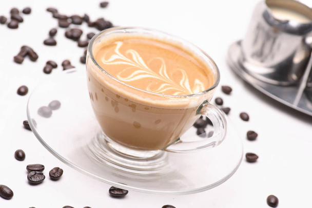 Kuuma Cappuccino kahvi kirkas lasi valkoisella pohjalla kahvipapuja
. - Valokuva, kuva