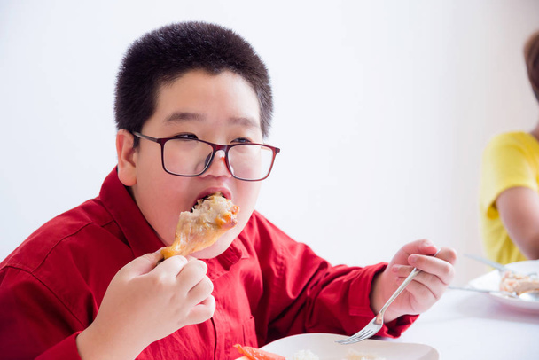 学校の食堂で焼き鶏を食べるアジア少年 - 写真・画像