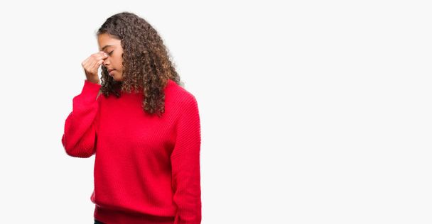 Mulher hispânica jovem vestindo suéter vermelho cansado esfregando nariz e olhos sentindo fadiga e dor de cabeça. Conceito de estresse e frustração
. - Foto, Imagem