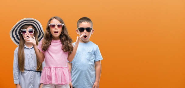 Skupina chlapce a dívky děti oranžové pozadí strach v šoku s tváří překvapení, strach a vzrušený výraz strachu - Fotografie, Obrázek