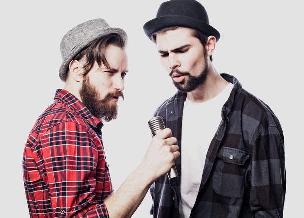 Two young mens singing with microphone. Isolated on white background. Friendship concept. - Φωτογραφία, εικόνα