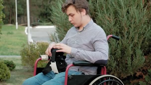 Postižený člověk v křesle invalidní vozík obléká přilbu virtuální realita - Záběry, video