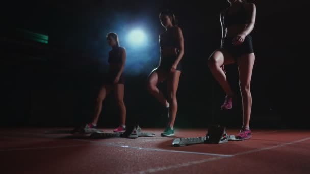 Fiatal női futó sportoló okosórával készen áll a futópálya rajtvonalának futtatására - Felvétel, videó