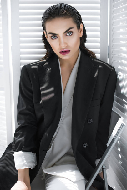 elegant fashionable girl with makeup posing in black jacket  - Фото, изображение