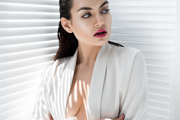 modelo elegante atraente posando na jaqueta branca na moda com sombras
 - Foto, Imagem