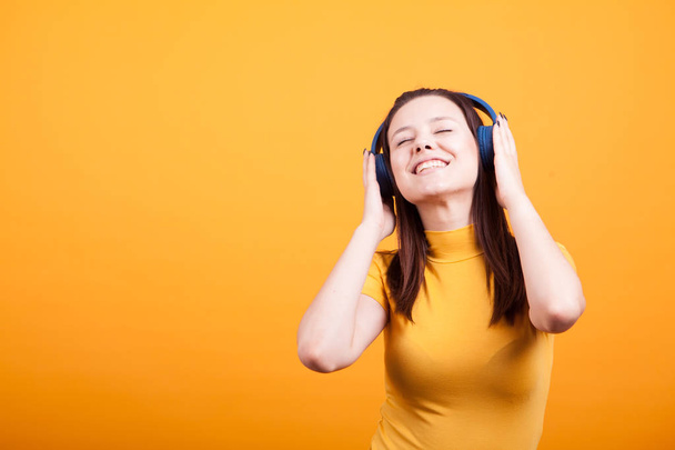 Cute young woman listening music in studio - Foto, afbeelding
