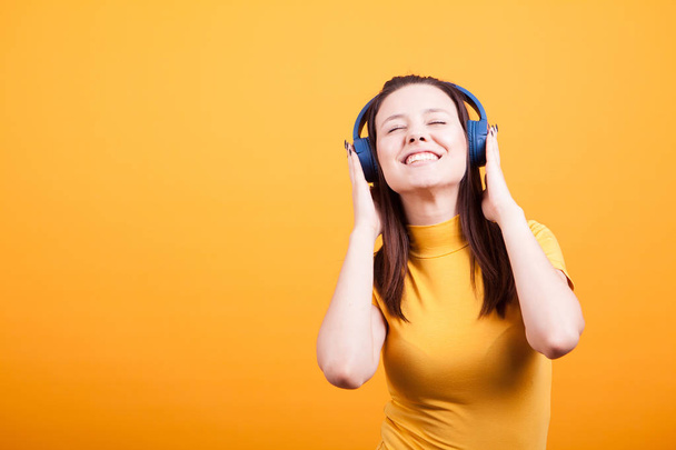 Aranyos fiatal nő hallgat zenét a studio - Fotó, kép