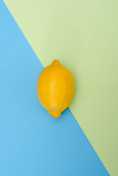 Один желтый лимон на зелено-синем фоне
 - Фото, изображение