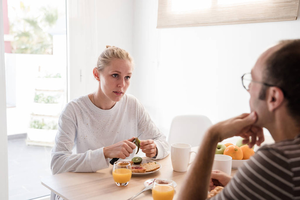Çift, bir kahvaltı ve konuşurken bir masada oturan adam elini çenesine üzerinde vardır - Fotoğraf, Görsel