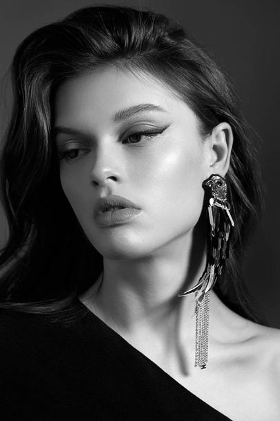 Black and white beauty portrait of young fashion model classic evening make up wearing stylish earrings - Фото, зображення