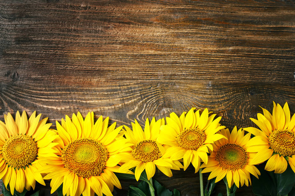 Beautiful sunflowers on a wooden table. View from above. Background with copy space. - Fotó, kép