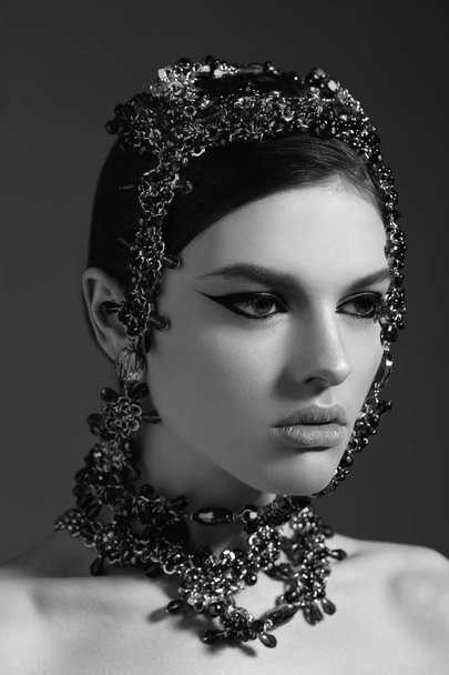 Black and white beauty portrait of young fashion model evening make up wearing stylish accessory on head - Foto, Bild