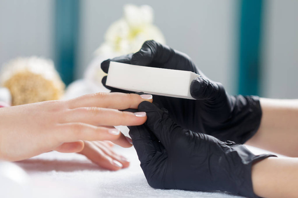 Woman hands receiving a manicure in beauty salon - Fotoğraf, Görsel