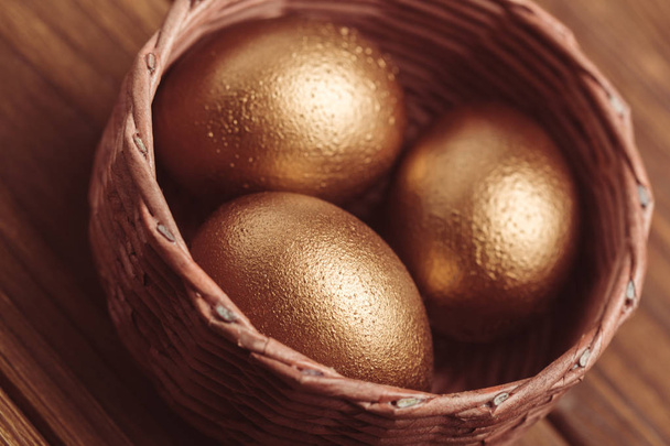 gold eggs on wooden table - Valokuva, kuva