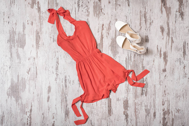 Concepto de moda. Armario de verano femenino. Mameluco naranja y zapatos blancos. Vista superior
 - Foto, imagen